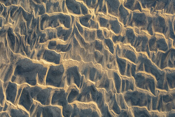 Natural sand patterns sculpted by wind, creating soft, flowing textures with intricate light and...