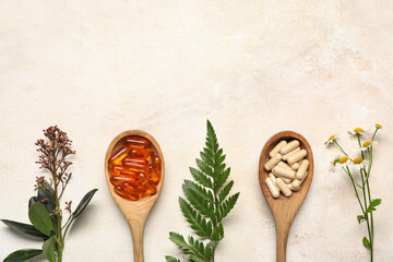 Composition with spoons of pills and plants on light background