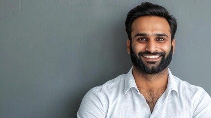 Obraz premium Smiling bearded Indian businessman, a small business owner, confidently looking at the camera in his office..