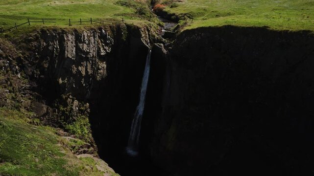 Aerial view of the beautiful, hidden gem Spekes Mill Mouth Waterfall located next to the Celtic Sea in Devon, UK