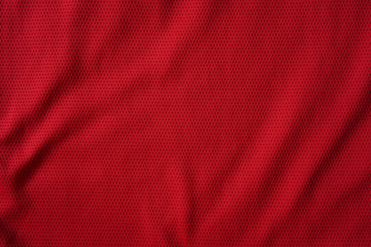 Close up of red football jersey sports clothing fabric texture.