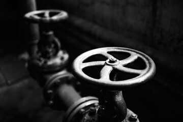 Industrial pair of valves ventil with flanges closeup selective focus over dark industrial...