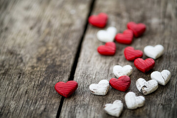 Red and white hearts scattered on a wooden table
