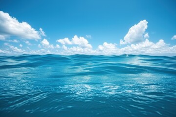 Open ocean view with gentle waves and clear blue sky scattered with fluffy white clouds, capturing the vastness and serenity of the sea