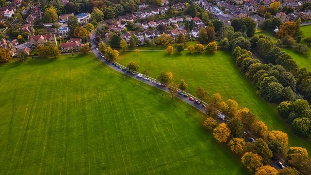 Aerial View of a Green Park with Winding Road