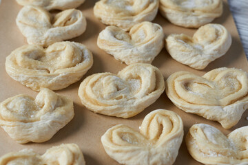 Raw heart-shaped buns on a baking sheet. Frozen convenience foods.