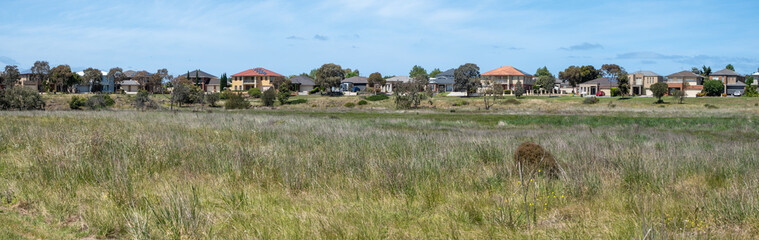 Australian Suburban Panorama: Established Homes Overlooking Native Grasslands in Residential Development in the suburb of Point Cook, Melbourne Australia.