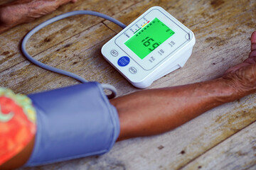 Monitoring blood pressure is essential for health management. This shows digital blood pressure monitor displaying readings on wooden surface, emphasizing importance of regular health checks