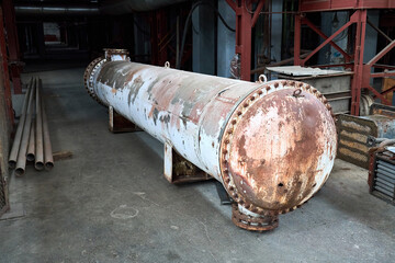 Industrial old faded heat exchanger on concrete floor. Dismantled heat exchanger with tubes at...