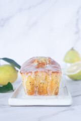 freshly baked homemade lemon poppy seed pound cake on white ceramic tray.