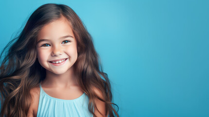 Naklejka premium Portrait of smiling latin american girl child blue background.