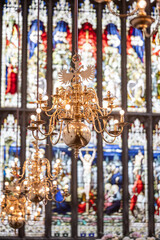 Ornate Golden Chandelier and Stained Glass in Church