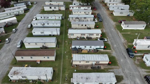 Aerial rising top down of cheap mobile homes trailer park in USA. Small wooden houses in social district of american metropolis. Unemployment theme.