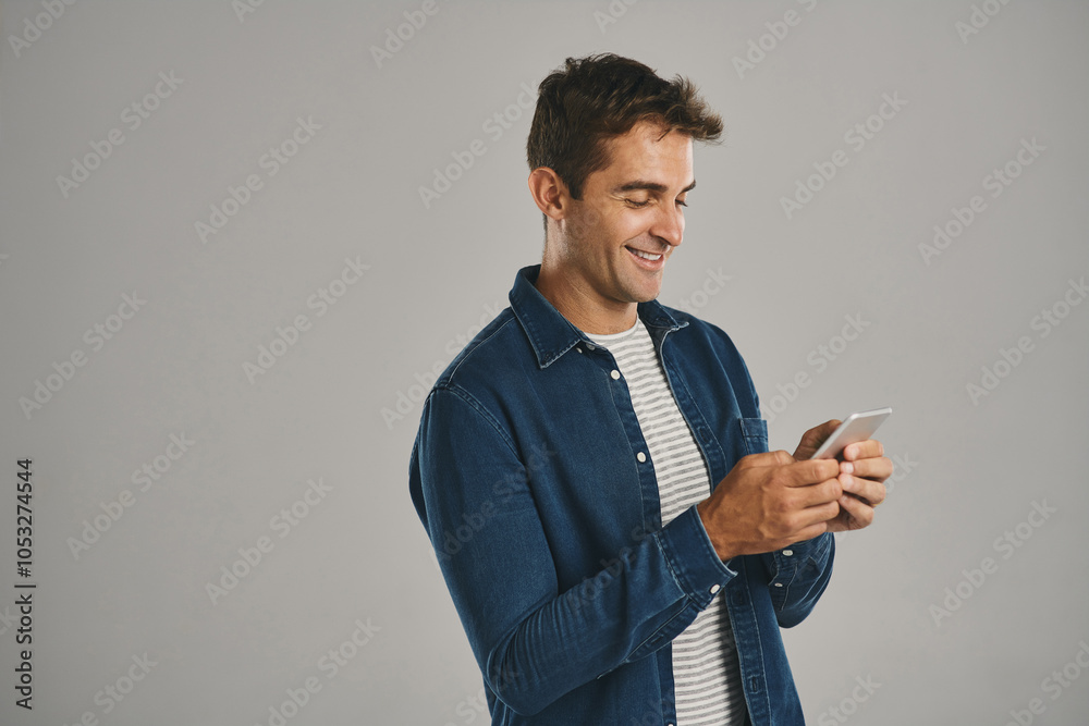Poster texting, man and smile with smartphone in studio for social media, post or mobile app on white backg