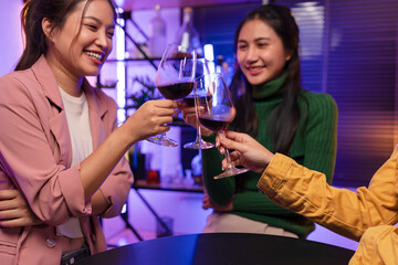 Asian women celebrating, meeting and chatting in a bar. Places to visit, beautiful lights
