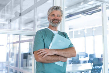 Gray-haired mature male doctor looking positive and confident