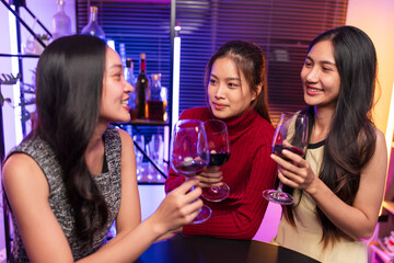 Asian women celebrating, meeting and chatting in a bar. Places to visit, beautiful lights