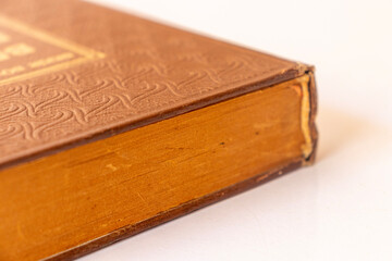 Damaged brown leather cover of a very old book. books standing horizontally and vertically. yellowed natural paper texture. isolated on white background. clean close-up.