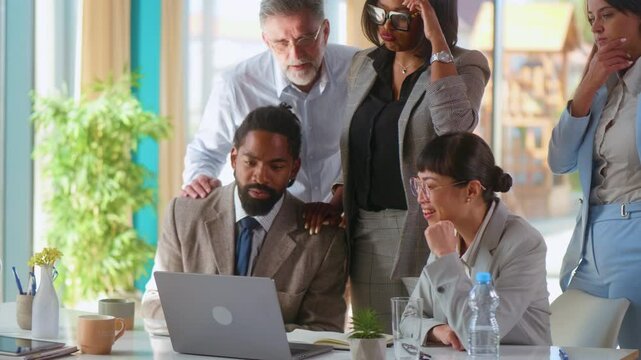 Worried multiracial business team is annoyed and feels tense while looking at the laptop, making important decisions, solving tasks, stress at work, tension, mistakes, negative feedback from client