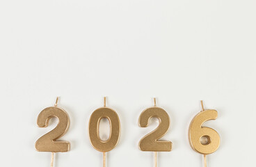 2026 Happy New Year. Top view of gold numbers on white background. Copy space, flat lay.