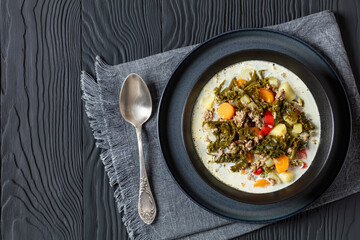 ground beef veggies kale soup in black bowl