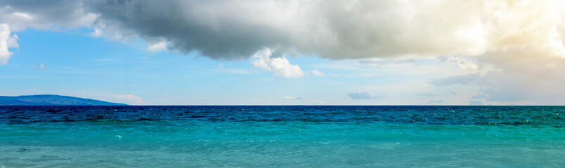 Fototapeta premium Ocean view with blue sky and clouds in the background