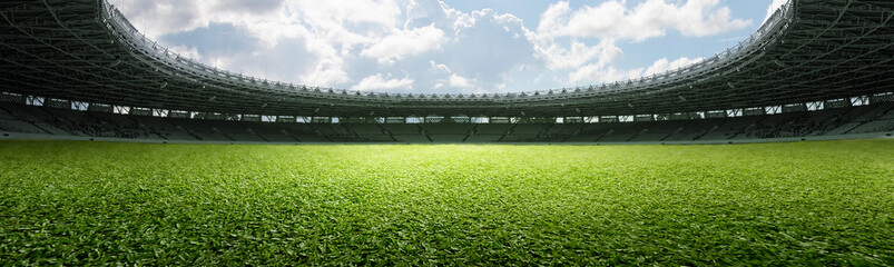 Empty football stadium with green field and blue sky. The field is ready for a game © Leo Lintang
