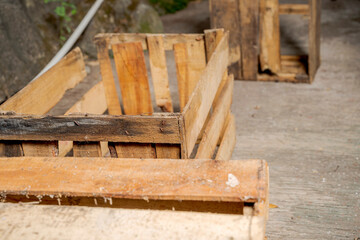 Wooden crate sitting on a concrete floor with stone wall background. Wooden pallet box