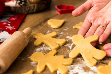 Female hands holding Christmas cookie prepared for baking, close up