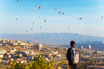 Person man watch hot air balloons over a city in Cappadocia