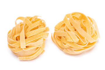 Two Classic Italian Raw Egg Fettuccine - Isolated on White Background. Dry Twisted Uncooked Pasta. Italian Culture and Cuisine. Raw Golden Macaroni Pattern - Isolation