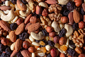 Mixed Nuts: Almonds, Walnuts, Cashews, Peanuts, Hazelnuts, Dried Prunes and Raisins. Different Nut Mix. Background from Various Nuts and Dried Fruits