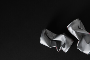 Two silver colored tin cans on black background, space for text