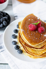 Pancakes with fresh berries and honey. on a wooden background. breakfast