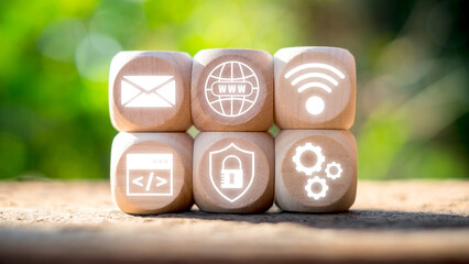 Wooden blocks displaying digital icons representing ASP.NET technology in a natural outdoor setting.