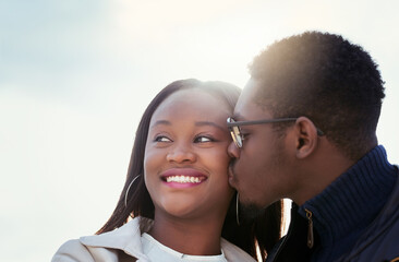 Kiss, happy and African couple in nature together for bonding, relationship and relaxing outdoors. Love, morning and man and woman with smile embrace for affection, romance and dating on weekend