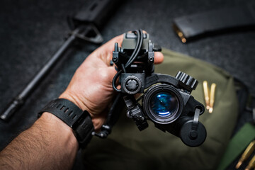 Night vision monocular with helmet mount in a man's hand. Modern military technology. © Dmitri