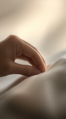 A close-up of a hand gently touching a soft fabric, evoking a sense of comfort and tranquility.
