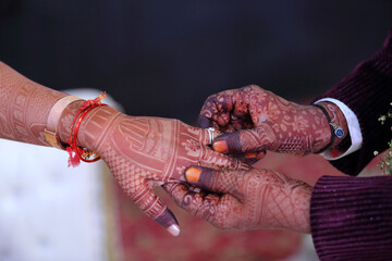 A moment of togetherness, marked by intricate henna designs and gentle hands, symbolizing love and commitment.