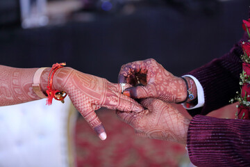 A moment of togetherness, marked by intricate henna designs and gentle hands, symbolizing love and commitment.