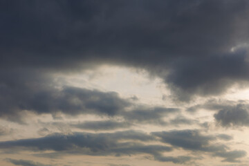 Fototapeta premium Grey clouds on raining sunset sky. Misty dusk. Dramatic view. Natural gloomy weather. Global warming, climate change. Moody and rainy nature background