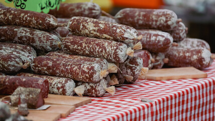 Fresh Italian salami displayed at a market in Alba during a vibrant food festival