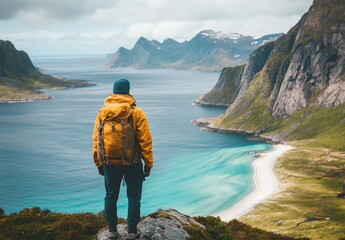 Fototapeta premium A man stands on a mountain top overlooking a beautiful lake