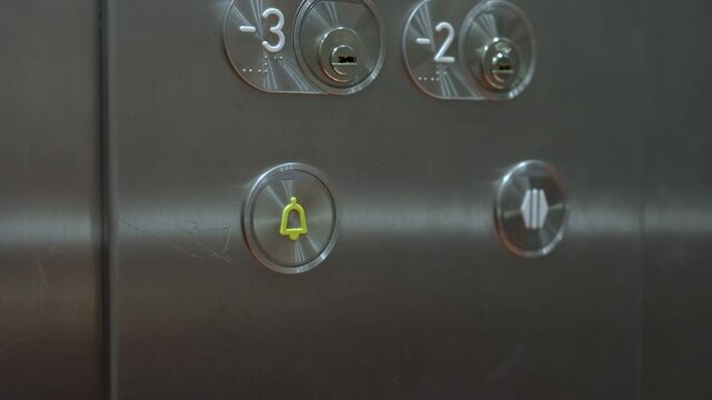 Closeup of hand pressing the alarm button in the elevator
