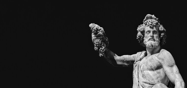 Paganism in Ancient Times. Roman or Greek god Bacchus holding grapes, a baroque statue, erected in the 17th century on Holy Trinity Bridge in Florence historic center (with blue sky and copy space)