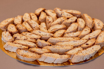 Close-up of multiple almond cantucci biscuits neatly arranged on a golden surface showcasing the crunchy texture and rustic charm of this traditional Italian dessert