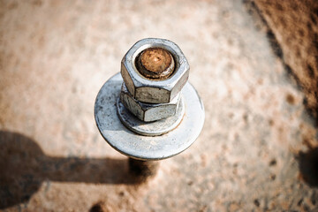 Construction site with embedded parts of reinforced concrete foundations showcasing a durable bolt in close-up view during daylight
