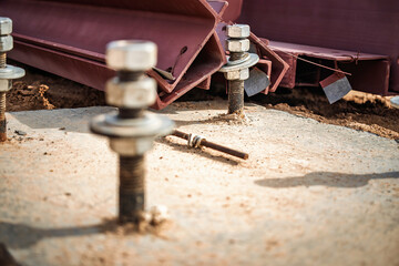 The construction process highlights embedded parts of reinforced concrete foundations at a building site during daylight hours