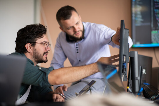 Programmers engrossed in deep collaboration, diligently working together to solve complex problems 