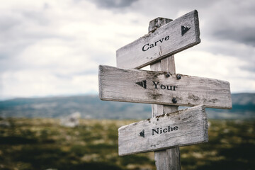 carve your niche text quote written on wooden signpost at the crossroads outdoors in nature.